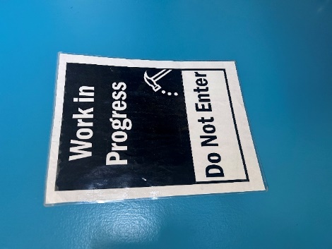 A sign on a blue surface
Description automatically generated