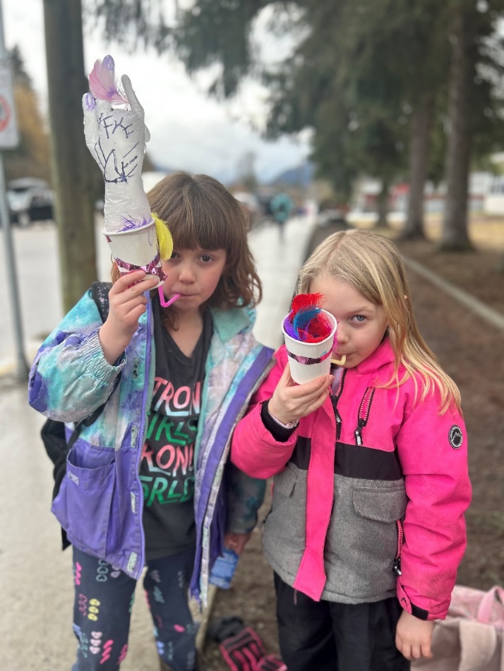 Two girls holding up a pinata

Description automatically generated