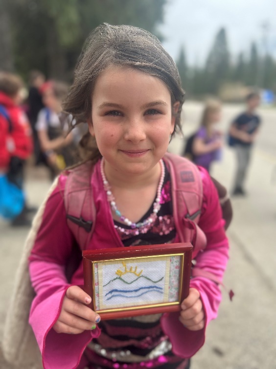 A child holding a picture frame
Description automatically generated