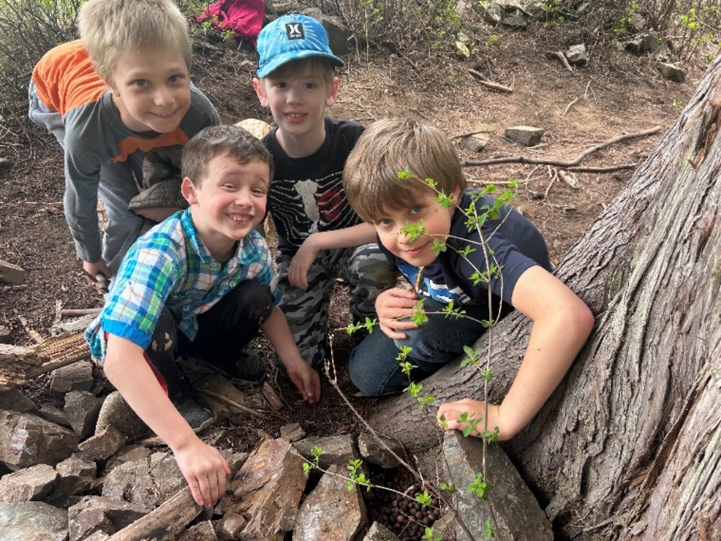 A group of boys sitting on a rock
Description automatically generated