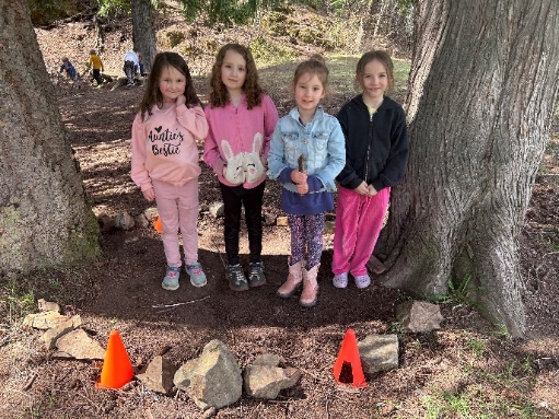 A group of girls standing in front of a tree
Description automatically generated