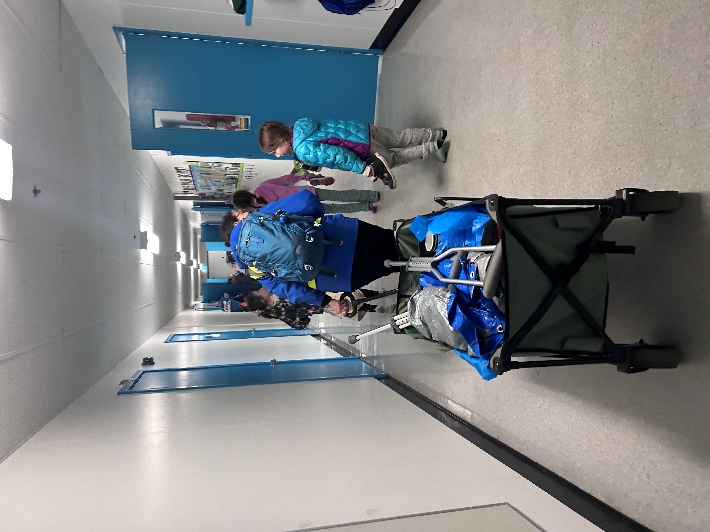 A group of people in a hallway
Description automatically generated