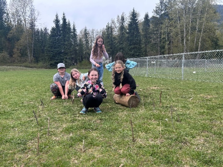 A group of kids on a grass field
Description automatically generated