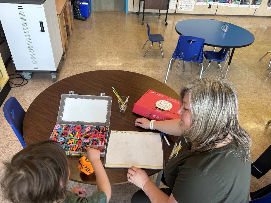 A person and a child sitting at a table
Description automatically generated