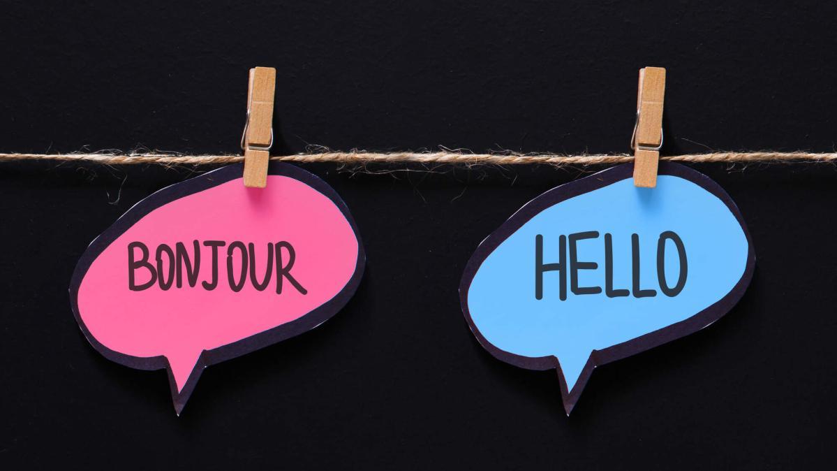 A black background with a string line and the words, Bonjour and Hello pinned to the string line.