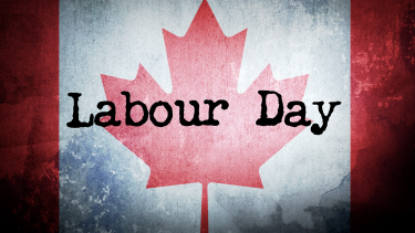 A faded Canadian flag with the words, "Labour Day" in black on top of the flag, in an old typewriter font.
