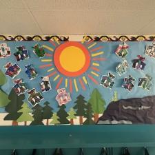 A multi-media artwork showing trees, the sky and a large sun.
