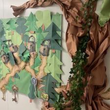 A poster of Sherwood Forest and a giant paper tree from the forest stuck on the wall beside it
