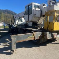 A yellow, white and blue crane in a school parking lot